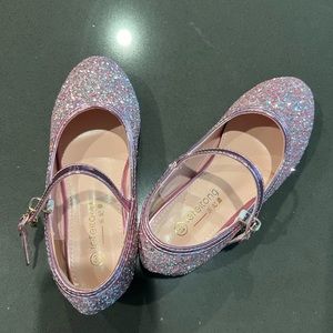 Pink glittered girl’s shoes with heels for birthday party or a fancy dinner.